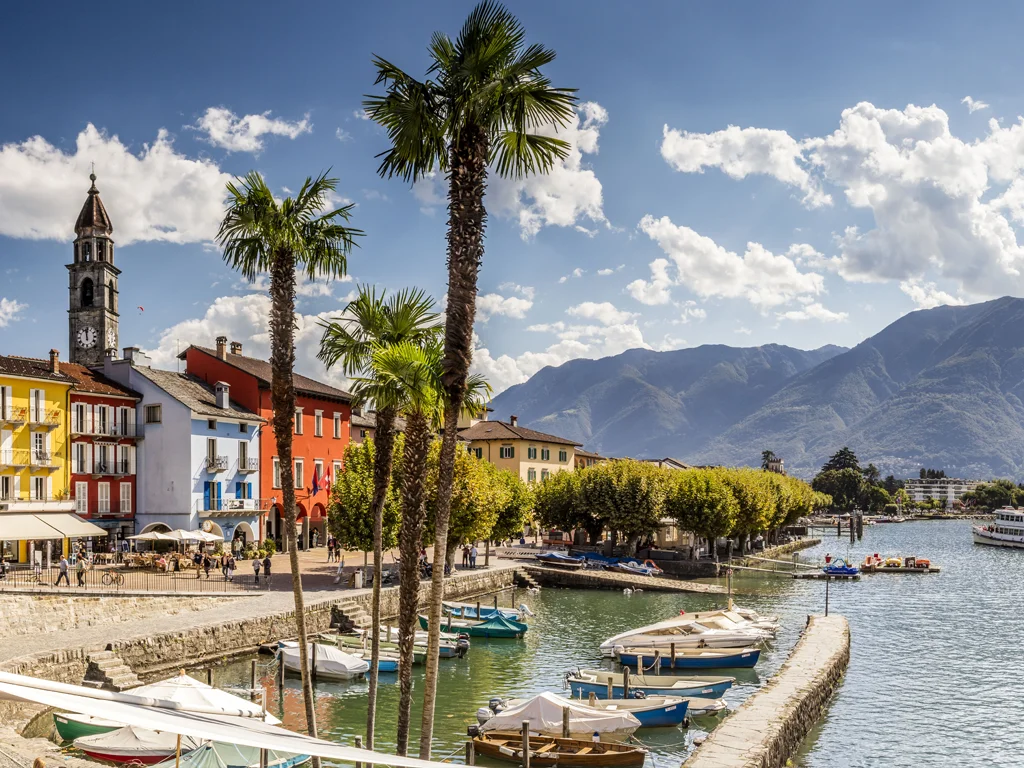 Seepromenade von Ascona mit Hafen, Palmen und Kirchturm