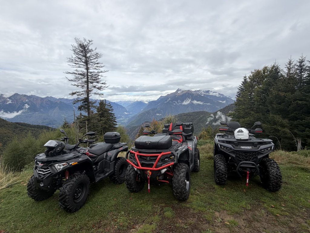 Drei Quads auf einer Alp mit Blick auf die Bergwelt zwischen Tessin und Graubünden