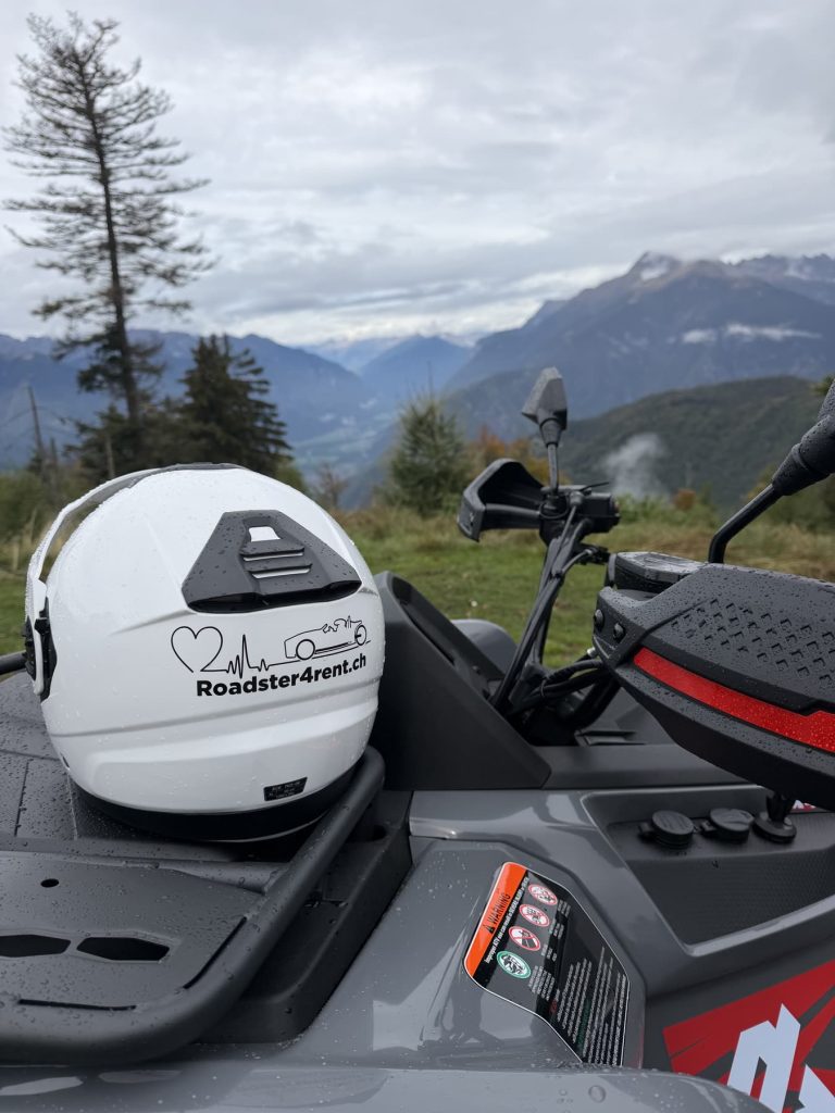 Helm mit Roadster4rent-Logo auf einem Quad vor Bergpanorama